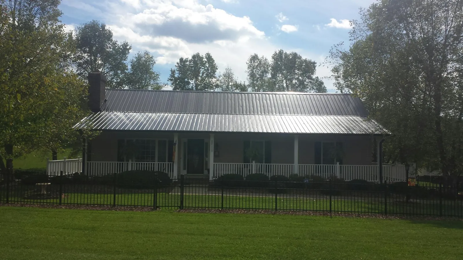 Gray metal roof on a brick ranch with a full width front porch — Gutter Guard Installation work by our crew in Pittsburgh