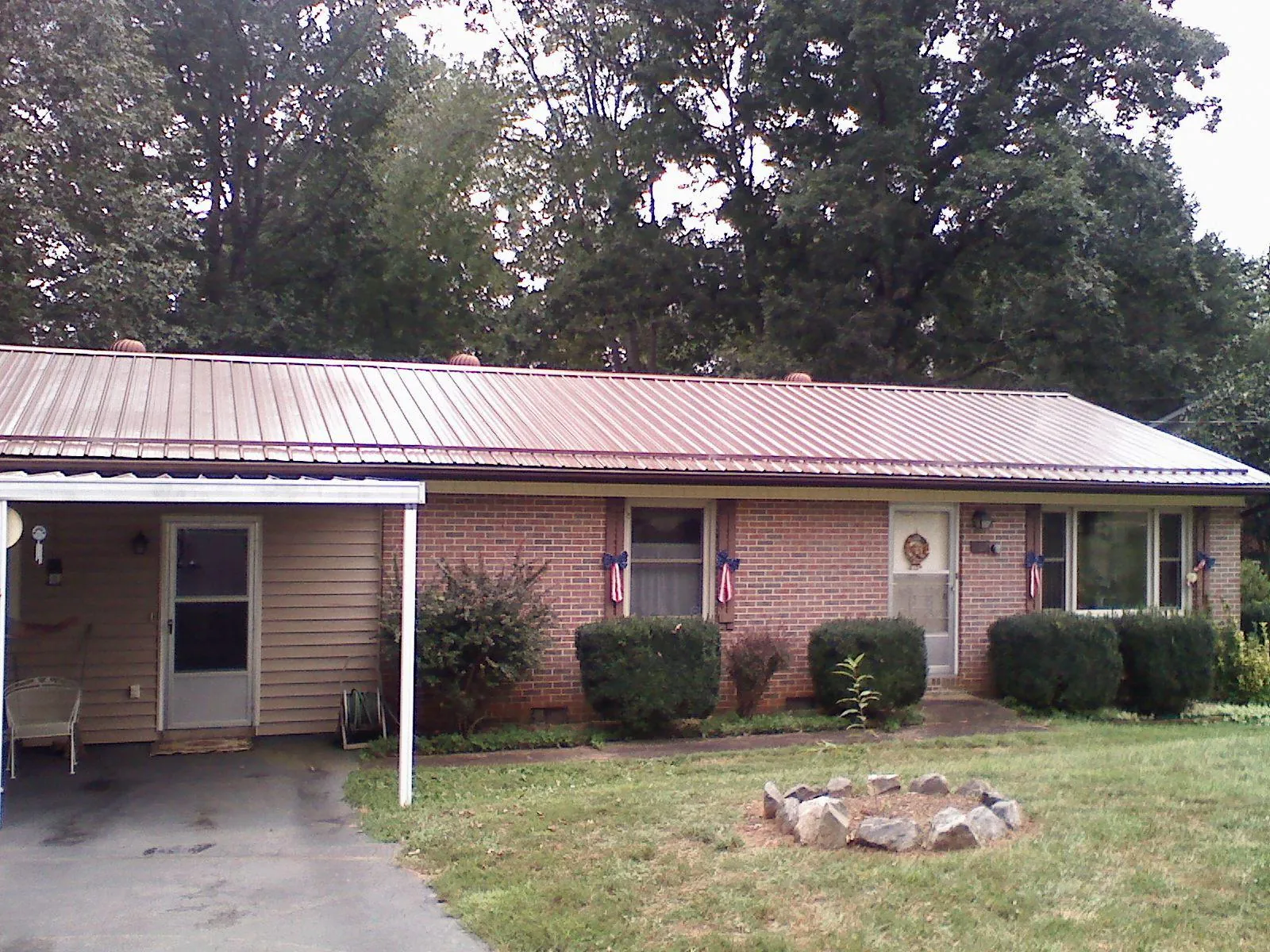Bronze metal roof and carport on a brick ranch home — Roof Repair work by our crew in Pittsburgh